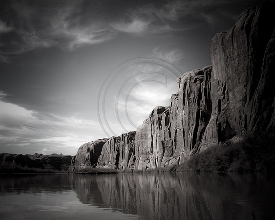 Rock wall bordering still water of the Colorado River, Moab, Utah